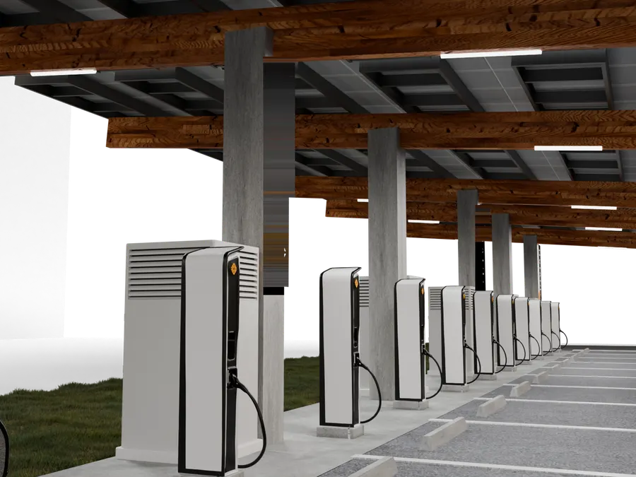 A night render of a charging station under a timber and steel canopy, with a row of charging units along a concrete deck.