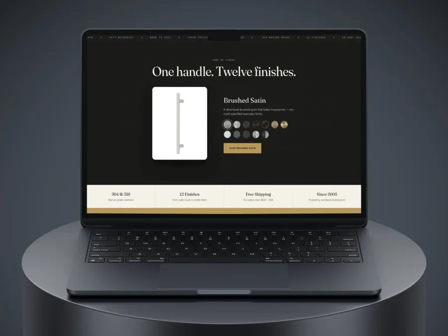An open laptop standing on a round dark pedestal against a charcoal background, its screen showing a dark web page headed One handle. Twelve finishes.