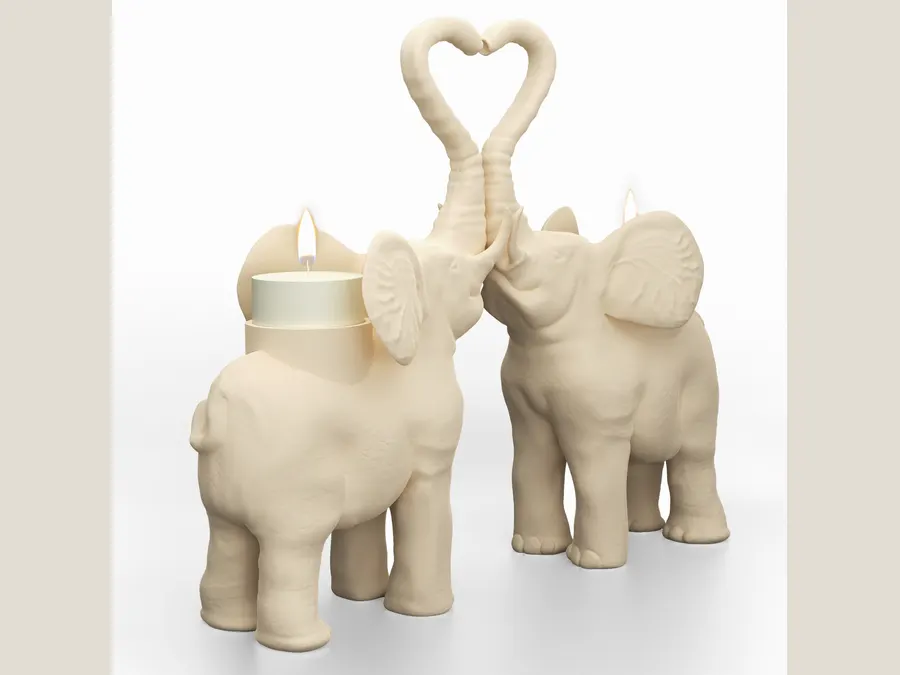 Two ceramic elephant candle holders, trunks raised and touching.