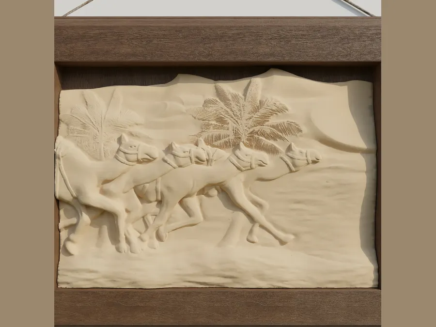 A carved relief panel of camels and palms, set in a wood frame.